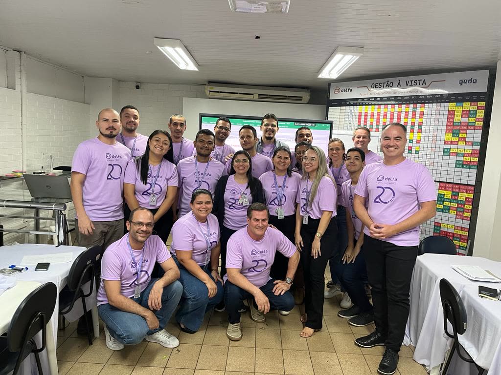 Equipe Delfa reunida em frente ao painel de gestão à vista implantado pela Deploy